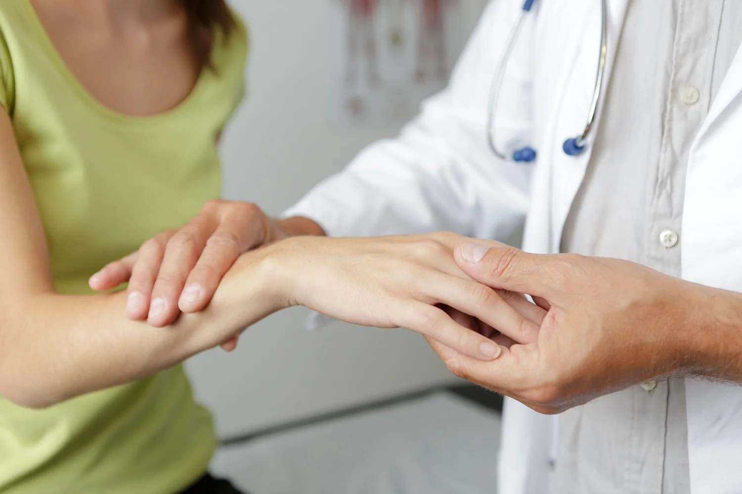 Specjalista bada bolącą rękę pacjentki. Diagnostyka przyczyn powodujących drętwienie rąk oraz ograniczoną ruchomość stawów