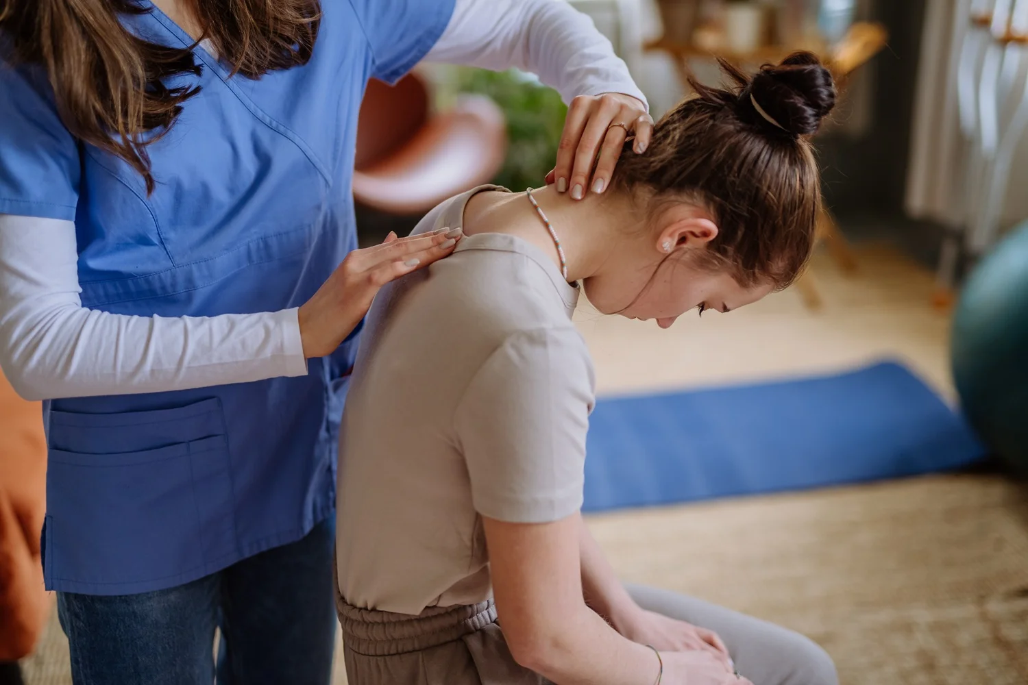 Fizjoterapeuta diagnozuje skrzywienie kręgosłupa u nastolatki. Skuteczna terapia, gdy występuje skolioza u dzieci i młodzieży